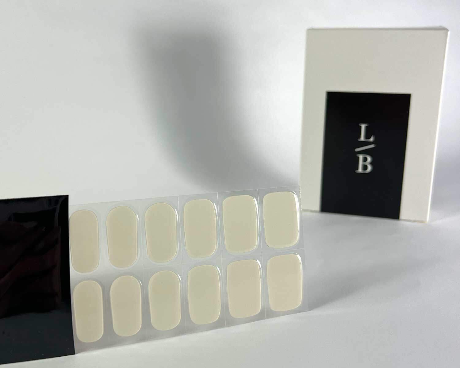 stone off white semi-cured gel nails in black light sensitive strip with la-bek uv lamp box in the background