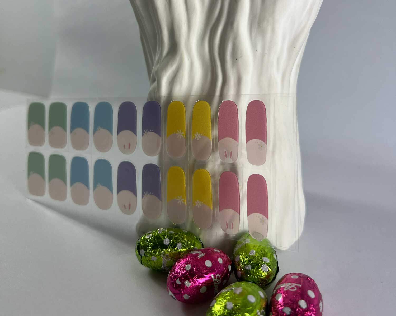 French bunny rainbow semi-cured gel nails in mockup to show product against textured white tree with la-bek uv lamp in the background