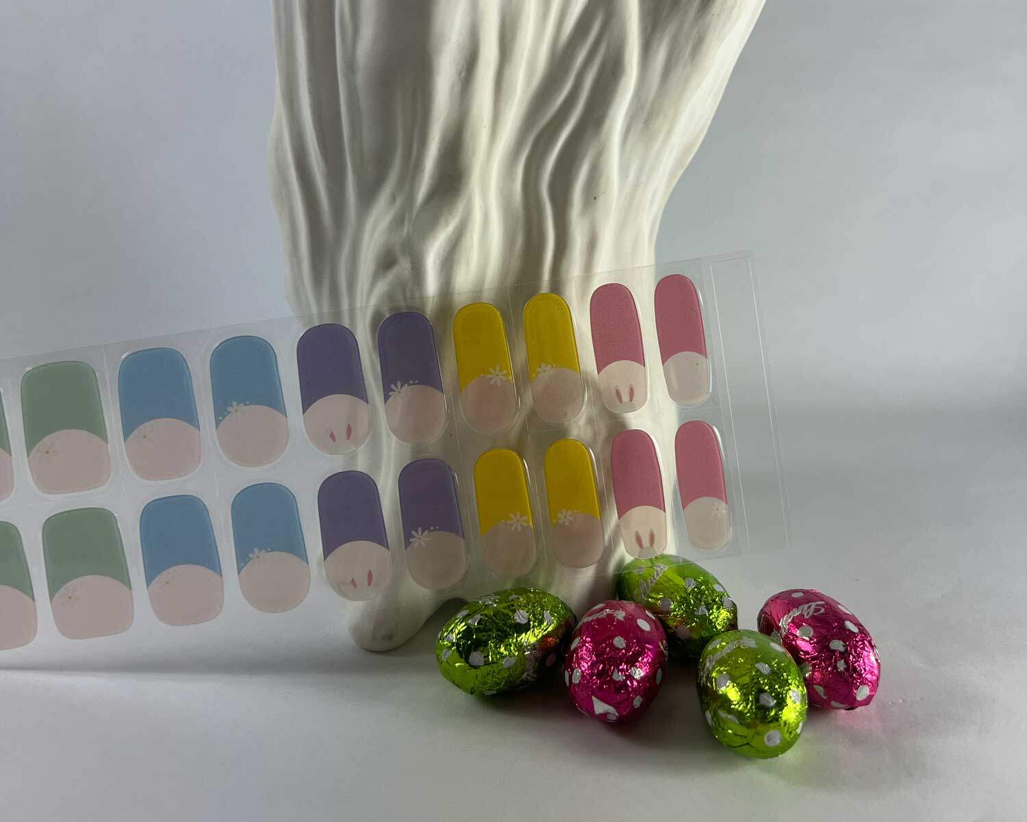 French bunny rainbow semi-cured gel nails in mockup to show product against textured white tree with easter eggs