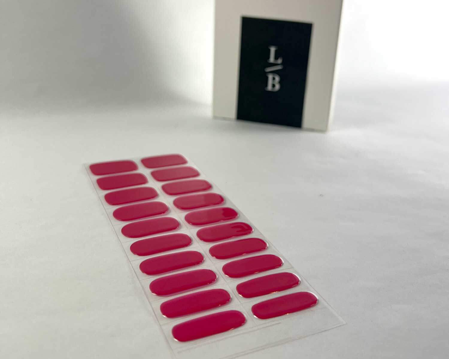 Lipstick love pink semi-cured gel nails on angle zoomed in on white background with la-bek uv lamp box in the background