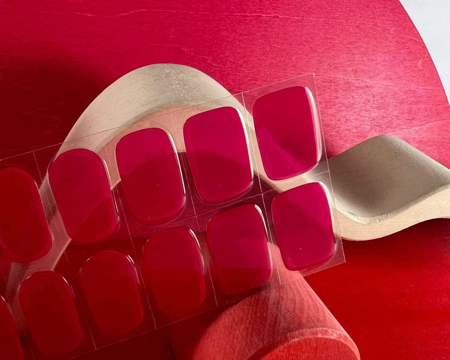 Lipstick love pink semi-cured gel nails zoomed in mockup to show product against red wooden blocks with la-bek uv lamp in the background
