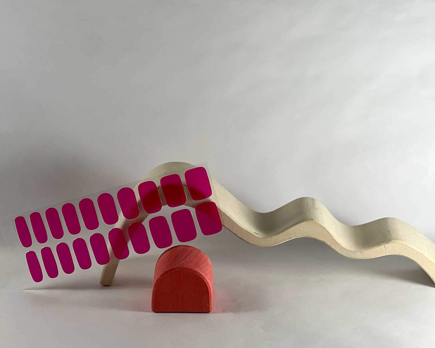 Lipstick love pink semi-cured gel nails in mockup to show product against red and white wave wooden blocks