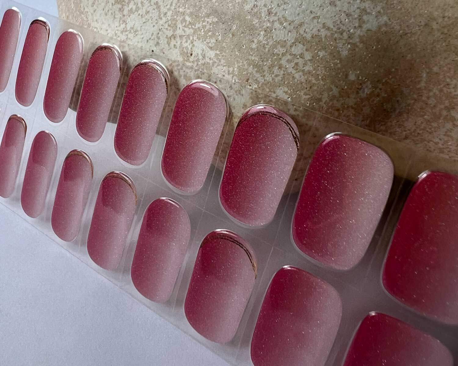 Golden sunset pink semi-cured gel nails in mockup to show product against ceramic textured head zoomed in