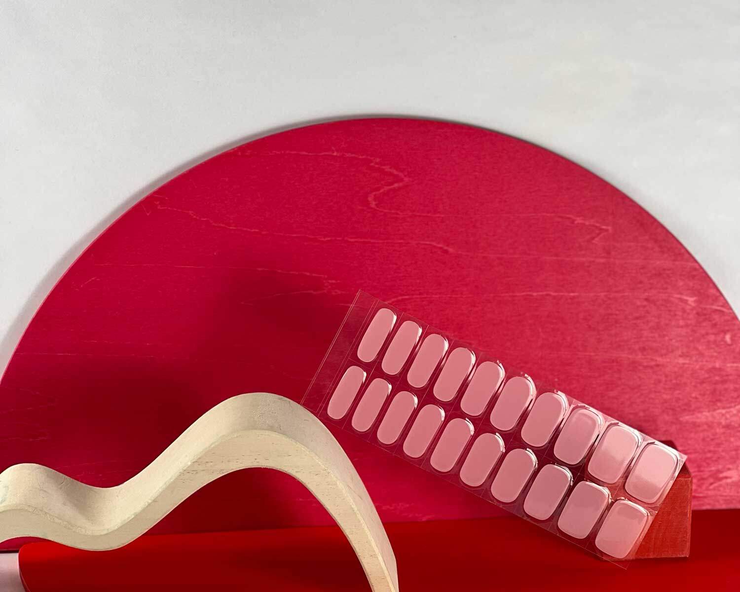 Pale pink power semi-cured gel nails in mockup to show product against red and white wooden blocks with la-bek uv lamp in the background