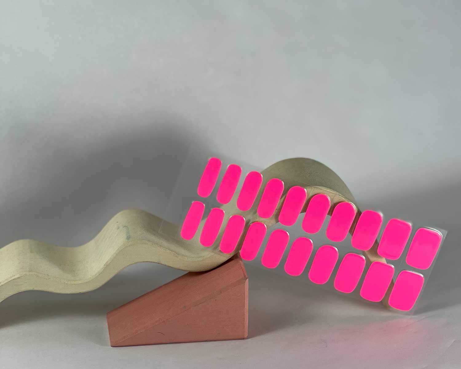 Barbie pink semi-cured gel nails in mockup to show product against white wave and pink wooden blocks