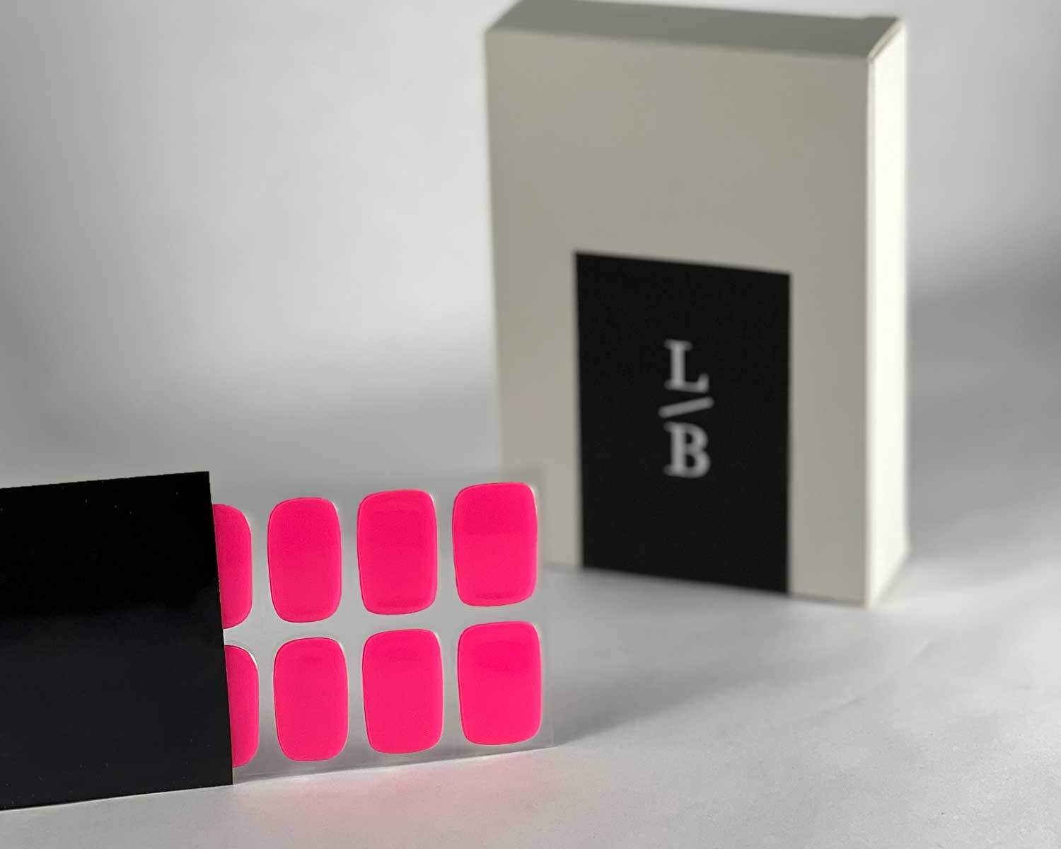 Barbie pink semi-cured gel nails in black light sensitive strip with la-bek uv lamp box in the background