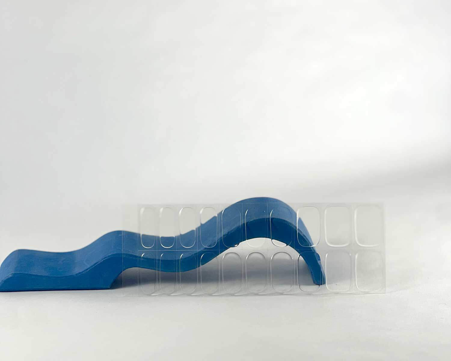 Transparent clear semi-cured gel nails in mockup to show product against blue wave wooden block