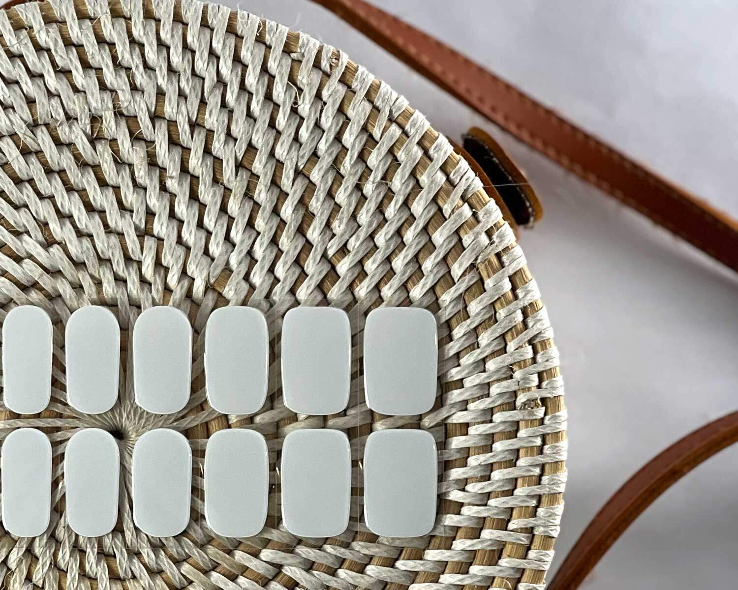 pure-white-semi-cured-nails-bag Pure White semi-cured gel nails in mockup to show product against textured handbag