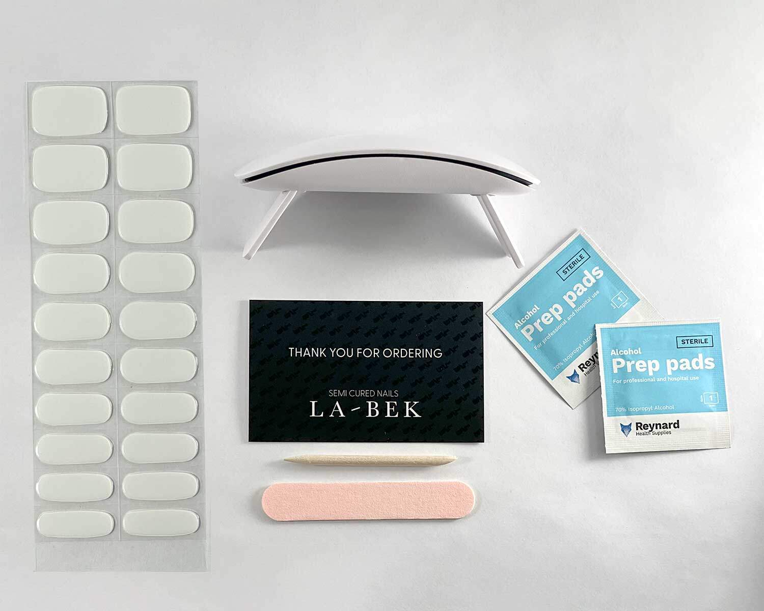 pure-white-semi-cured-nails-bag-flaylay Pure White semi-cured gel nails in flat lay showing uv lamp, thank you for ordering card, prep pages, nail file