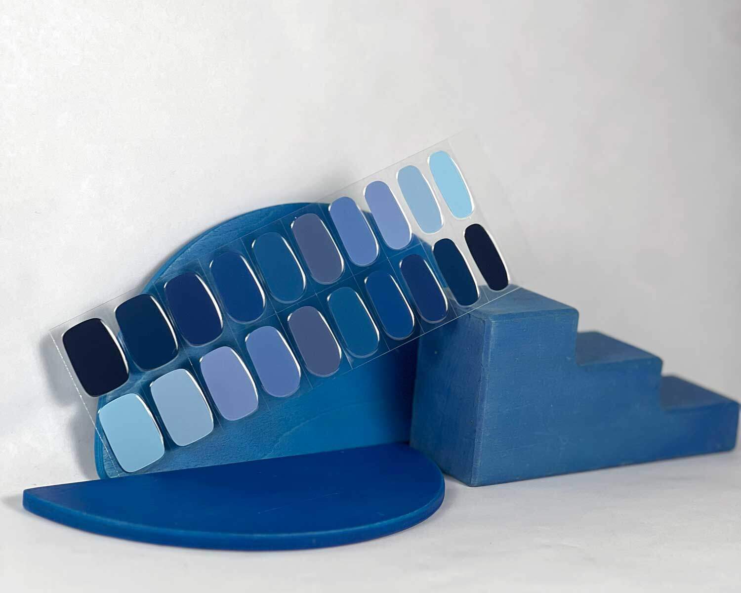Blue Mixed semi-cured gel nails in mockup to show product against blue wooden blocks