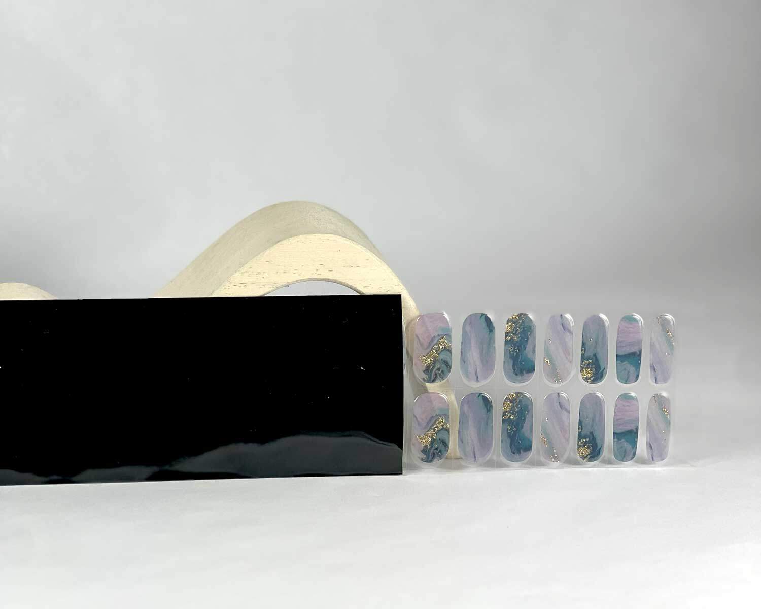 Opal Glitter Gold semi-cured gel nails in black light sensitive strip with la-bek uv lamp box in the background