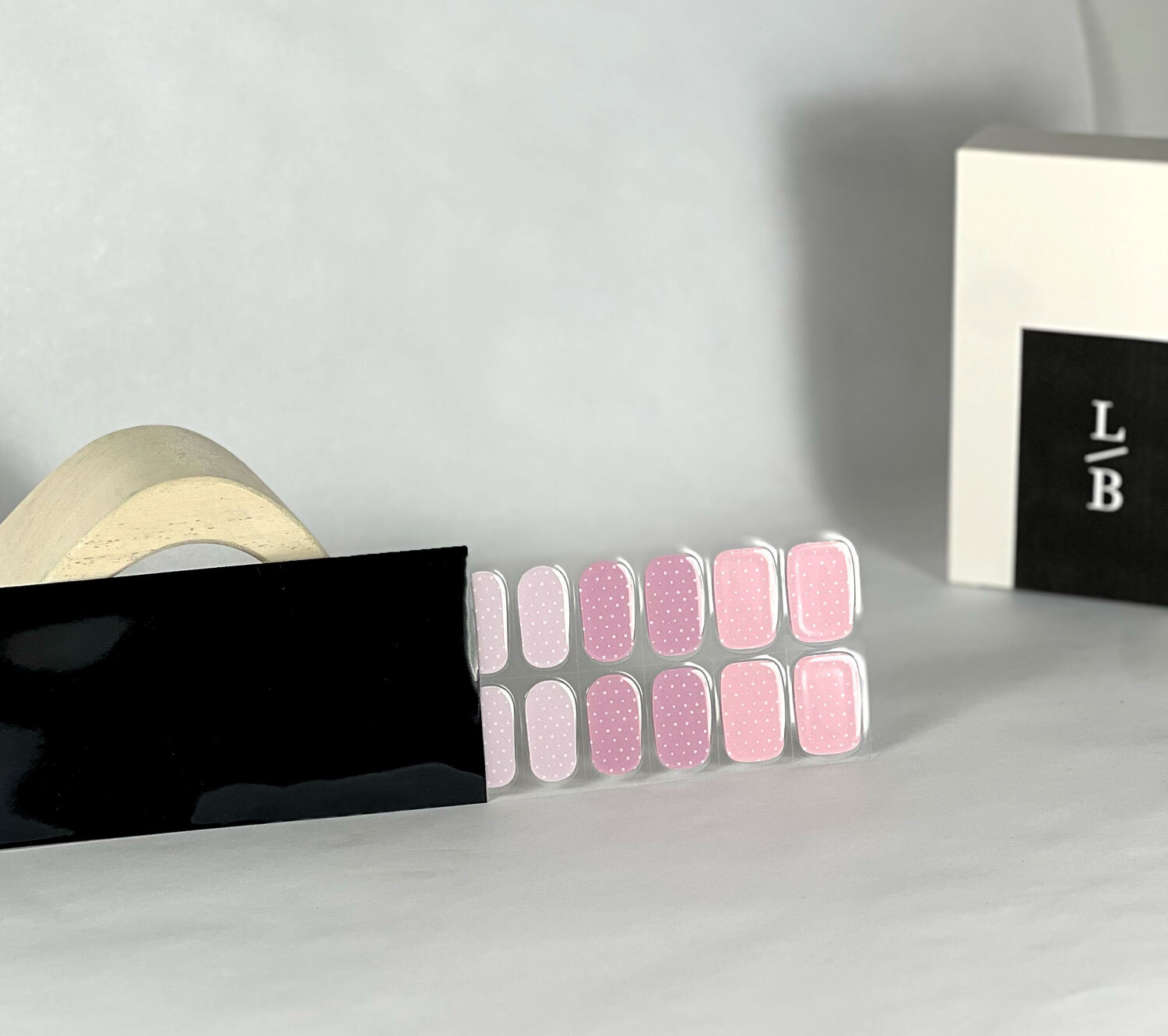 Pastel Polka Dots semi-cured gel nails in black light sensitive strip with la-bek uv lamp box in the background