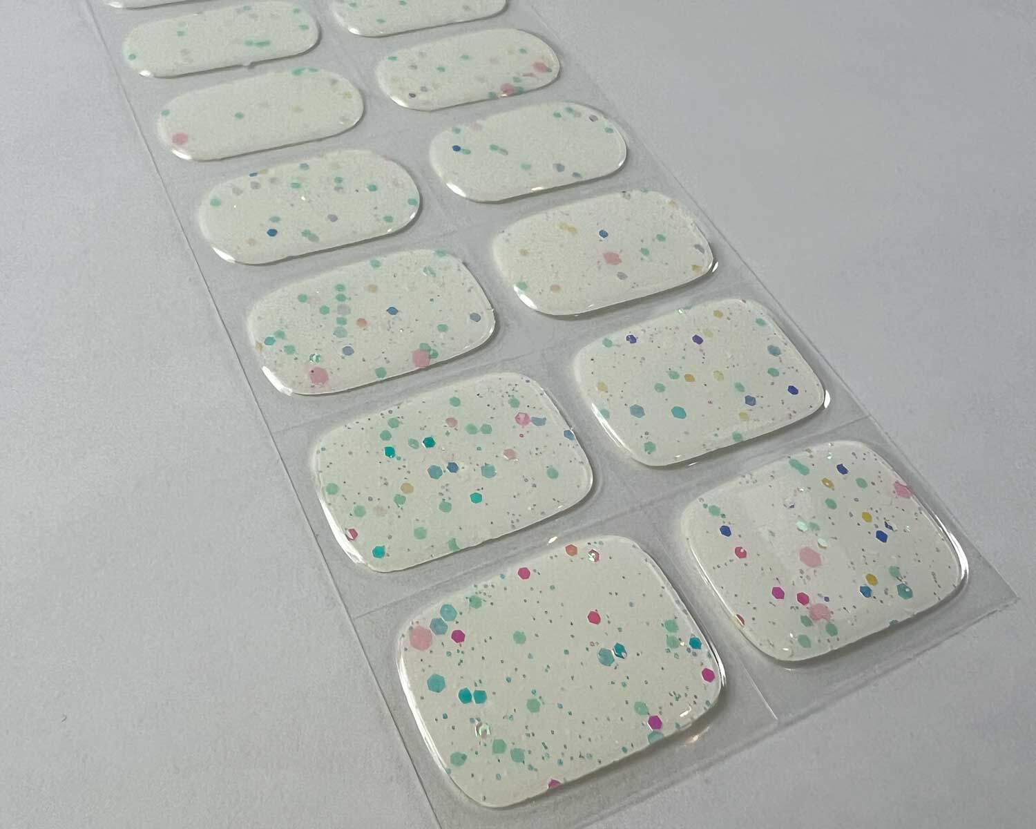 Sprinkle-Glow-Snow-semi-cured-gel-nail-zoom Sprinkle snow Glow in the dark white semi-cured gel nails on angle zoomed in on white background