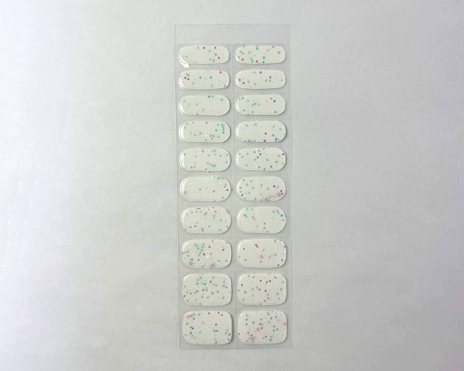 Sprinkle-Glow-Snow-semi-cured-gel-nail-STRIP Sprinkle snow Glow in the dark white semi-cured gel nails strip showing 20 pieces with 10 different sizes on white background