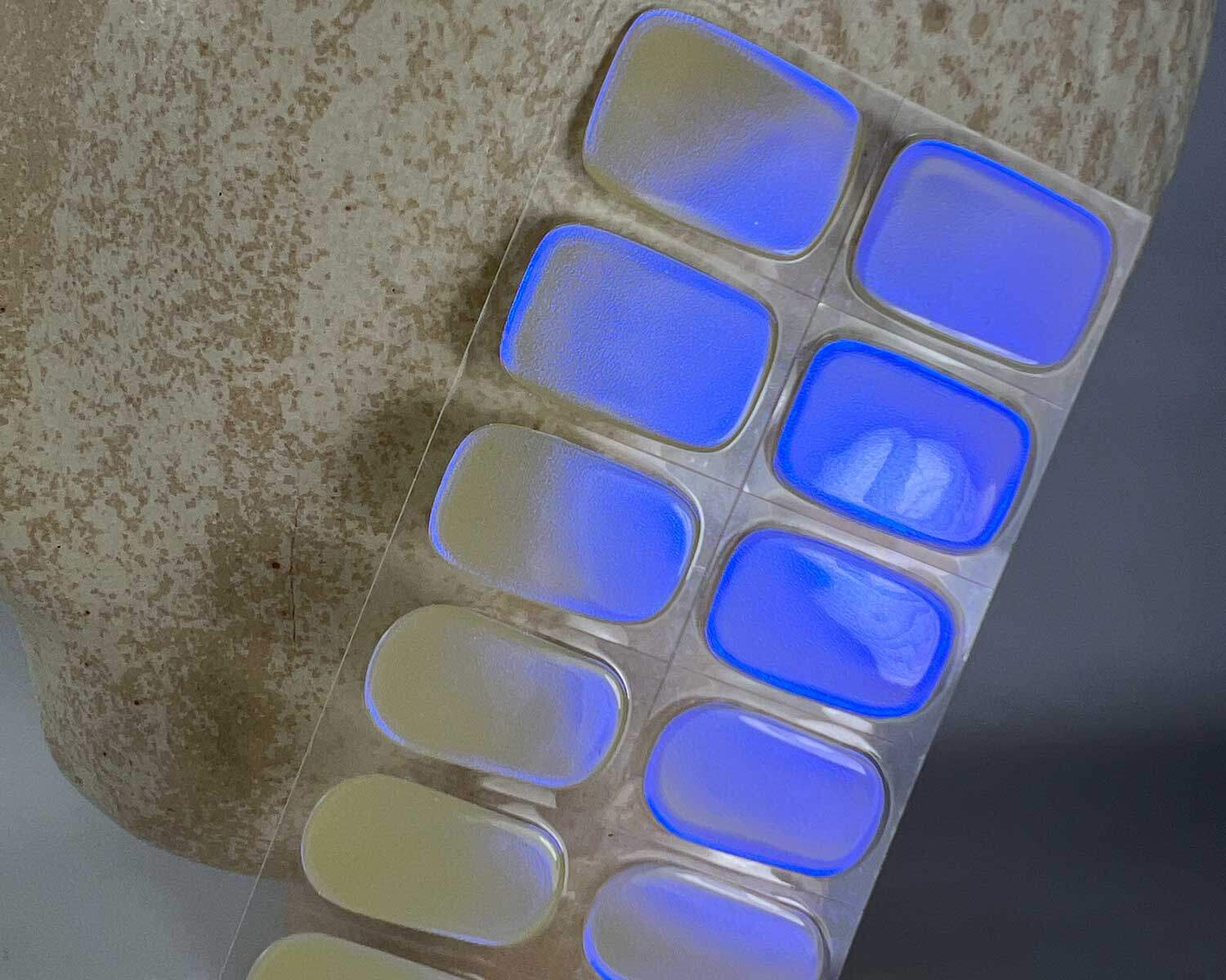 Pearlescent Lemon yellow blue semi-cured gel nails in mockup to show product against a white textured ceramic head zoomed in