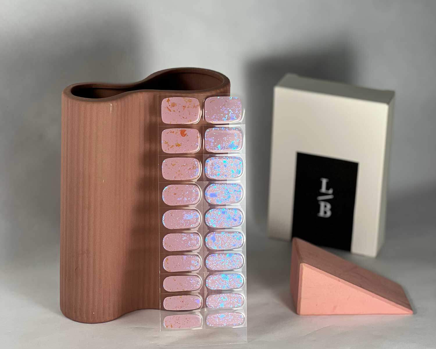 pink-speckle-semi-cured-gel-nail-mock Pink Speckle Orange semi-cured gel nails in mockup to show product against oeach vase with la-bek uv lamp in the background