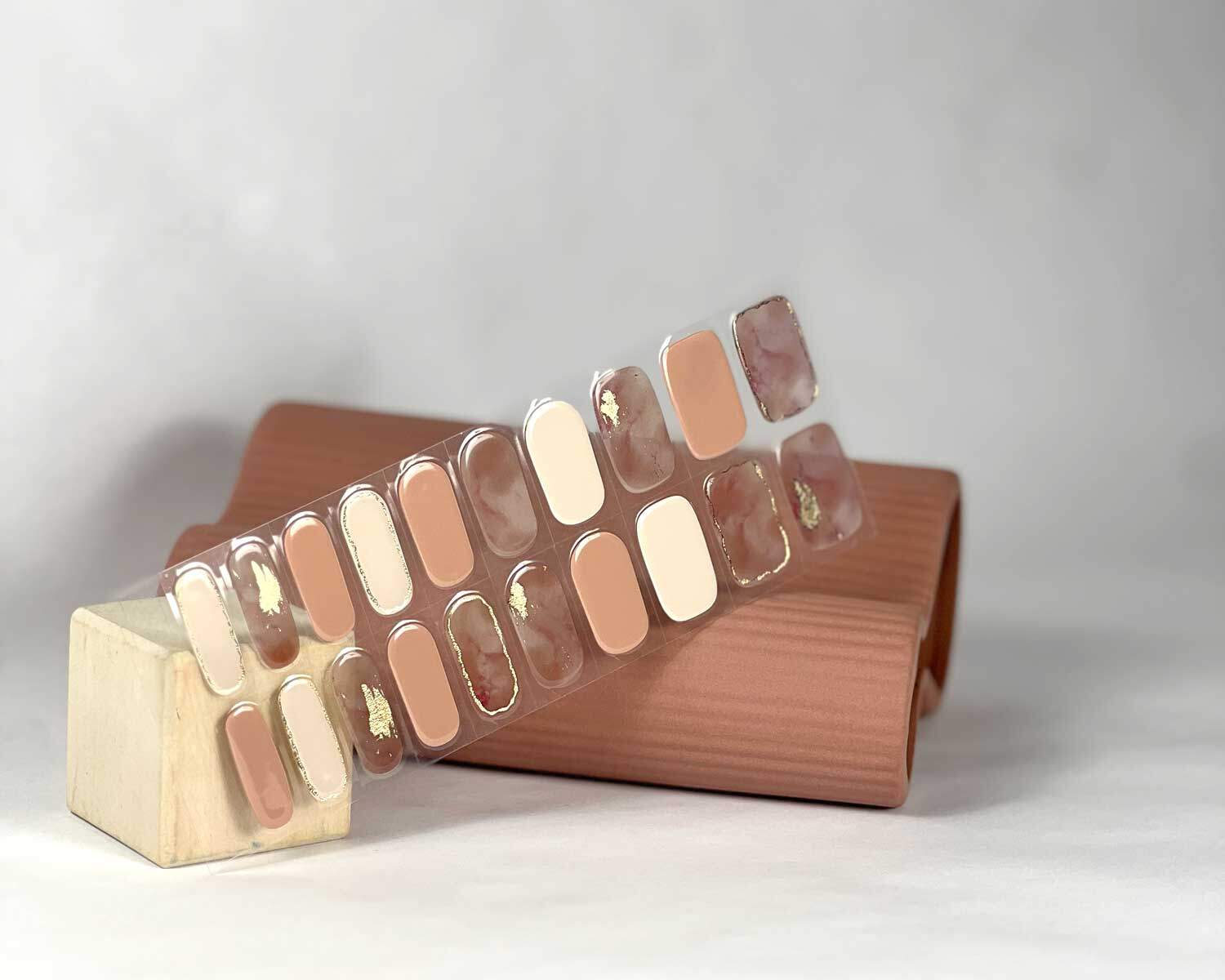 Gold Digger semi-cured gel nails in mockup to show product against pink vase and white wooden block