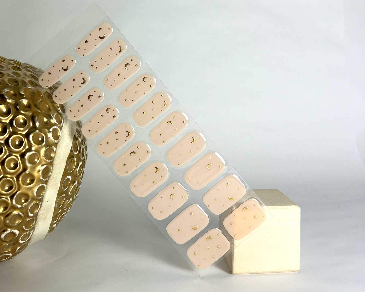 moon child semi cured gel nails in mockup to show product against white wooden block and golden budda head