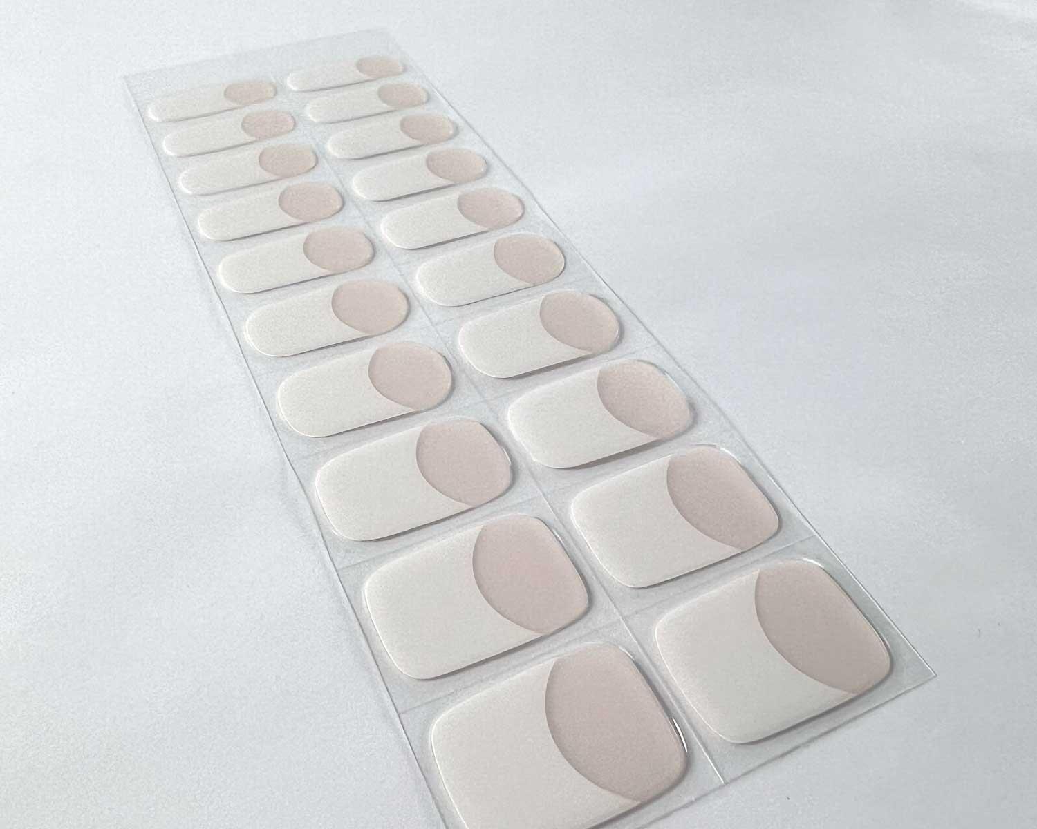 classic french semi cured gel nails on angle zoomed in on white background