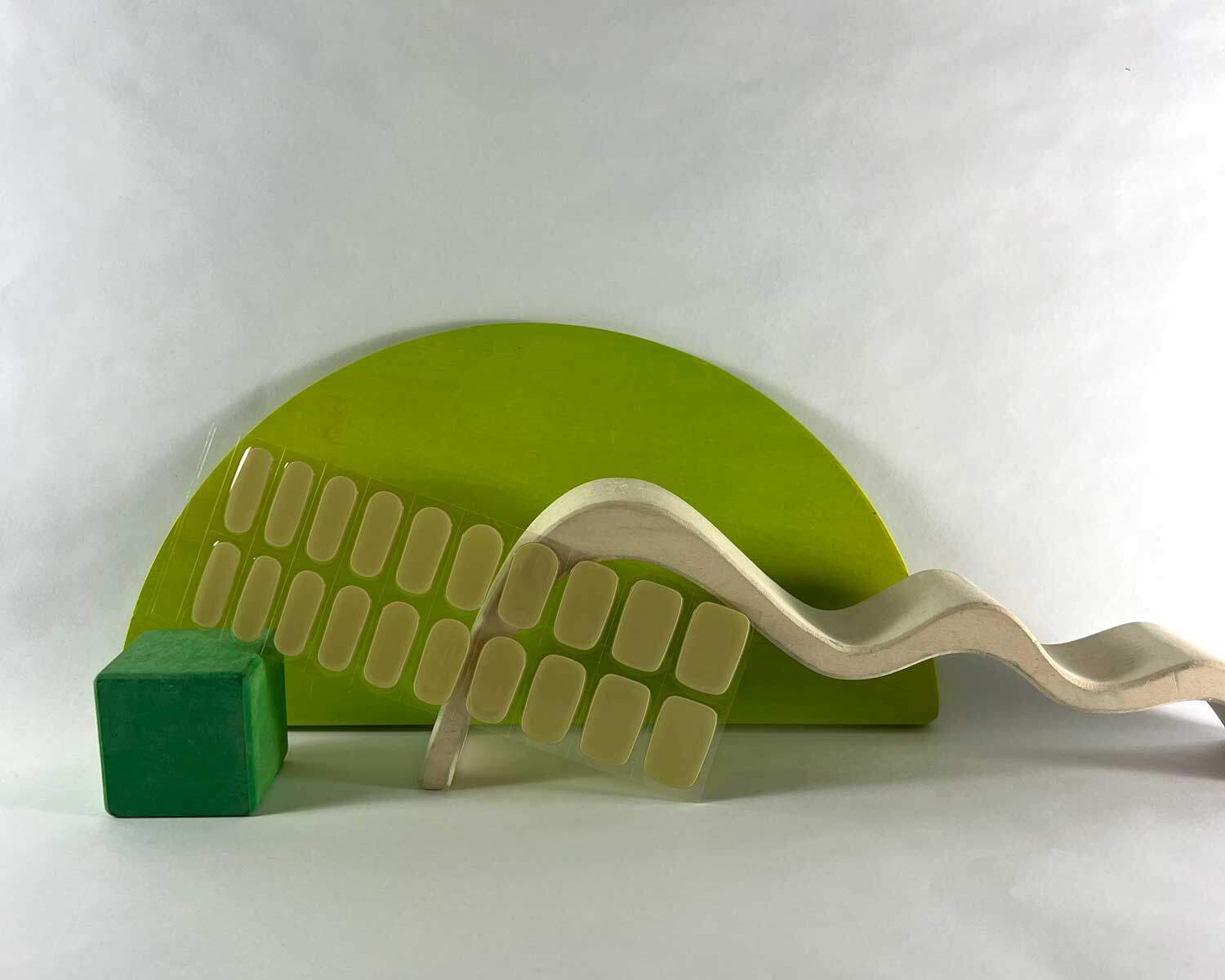 artichoke green semi-cured gel nails in mockup to show product against green wooden blocks