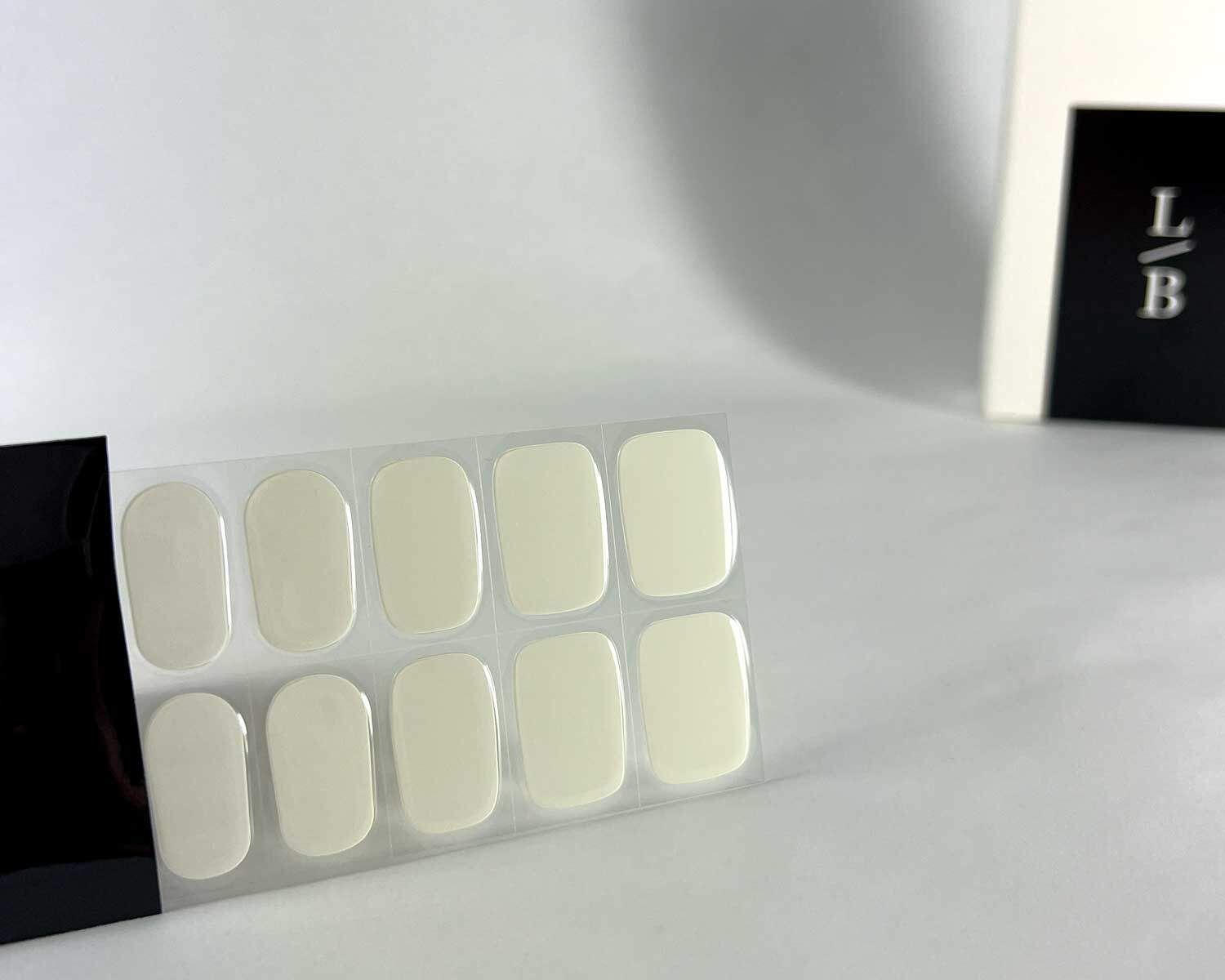 semi-cured-Gel-Nail-Sticker-storm-black-strip storm white grey semi-cured gel nails in black light sensitive strip with la-bek uv lamp box in the background