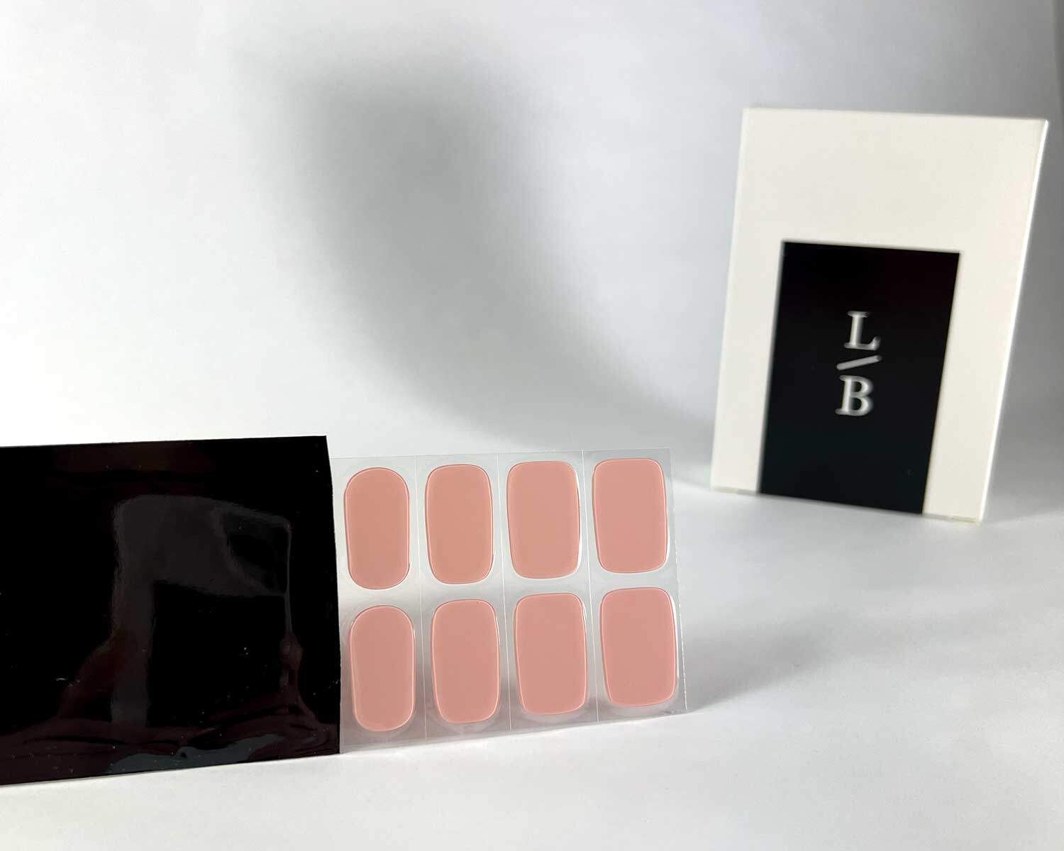 pink marshmallow semi-cured gel nails in black light sensitive strip with la-bek uv lamp box in the background